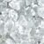 A close-up of a large pile of fresh, clean ice cubes. Tiny water droplets are on the melting cubes.