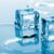 Two melting ice cubes sit in a shallow pool of water as smaller ice pieces blur across the cool blue background.